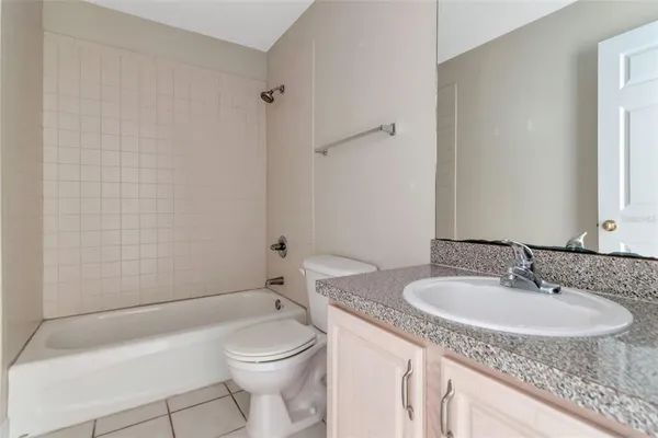 a bathroom with a granite countertop sink a toilet and a mirror