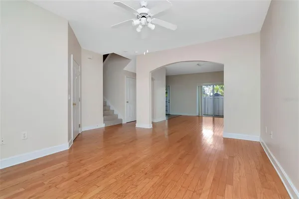 a view of a livingroom with wooden floor and a ceiling fan