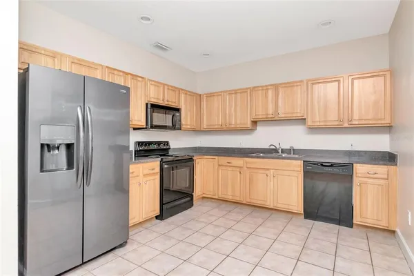 a kitchen with stainless steel appliances granite countertop a refrigerator sink and cabinets