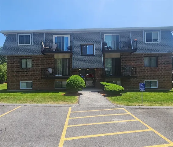 a view of a brick house with a yard in front of it