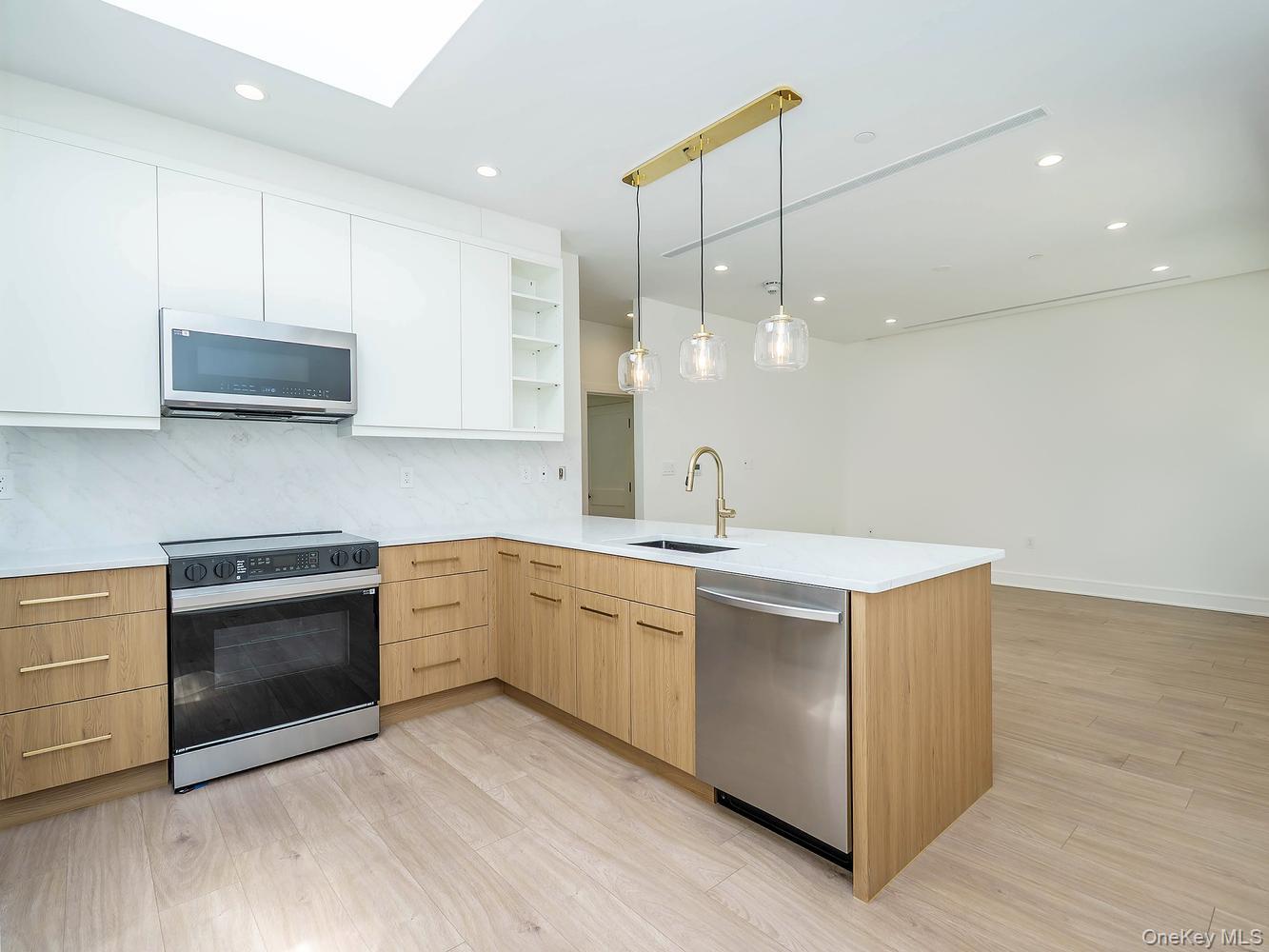 24 Lumber Road, Unit 1 Roslyn, NY 11576 - Photo 5 of 18 a kitchen with a sink cabinets and stainless steel appliances