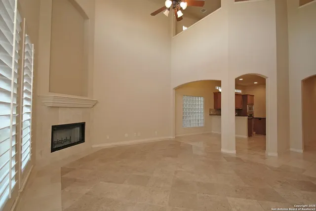 a view of an empty room with a fireplace and a window