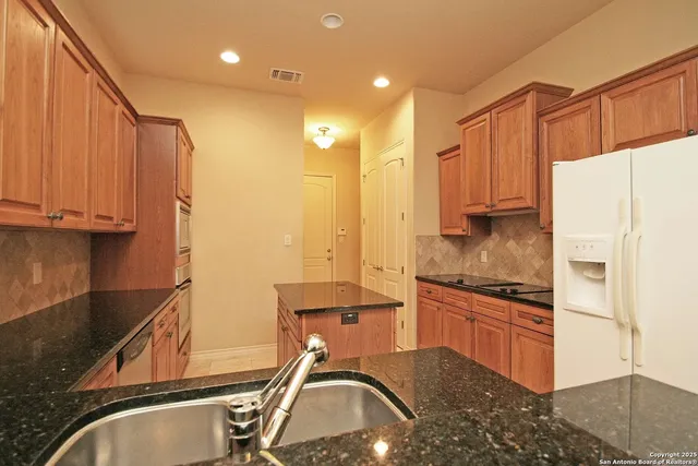 a bathroom with a granite countertop sink and mirror