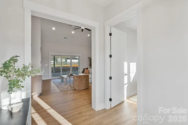 a view of a hallway with wooden floor and chair