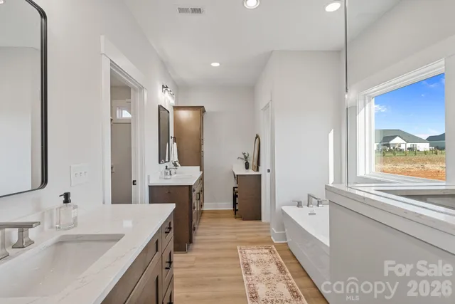 a spacious bathroom with a granite countertop sink mirror and bathtub