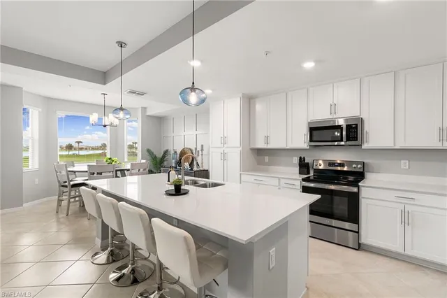 a kitchen with a sink a stove and chairs
