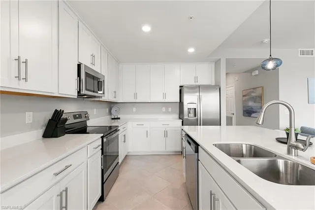 a kitchen with a sink cabinets and appliances