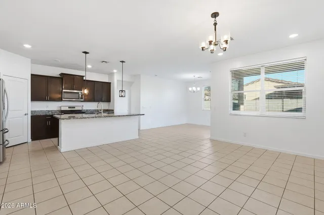 a large white kitchen with kitchen island granite countertop cabinets and stainless steel appliances