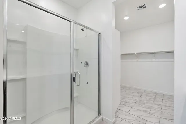 a bathroom with a shower and a glass door