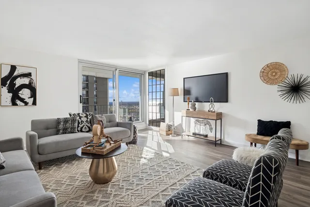 a living room with furniture a rug and a flat screen tv