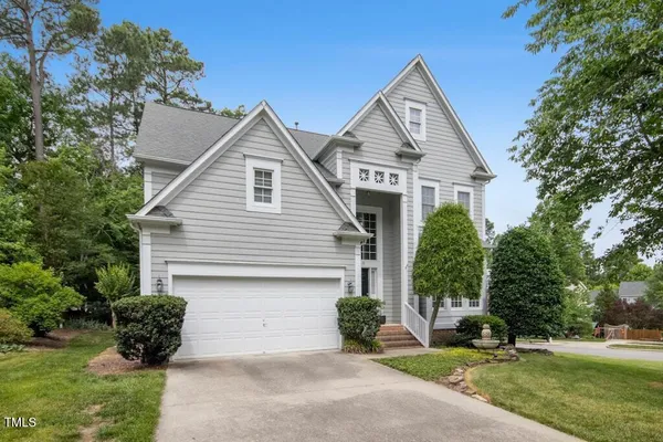 a view of a house with a yard and potted plants