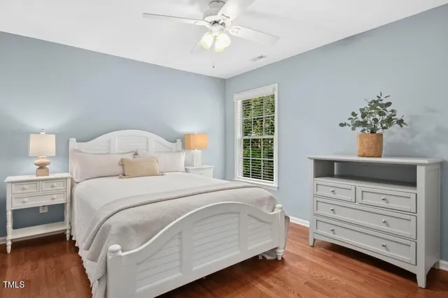 an empty room with wooden floor cabinet and windows