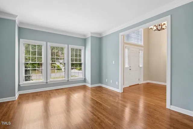 a view of a room with wooden floor chandelier and windows