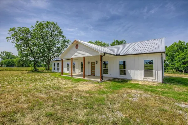 a view of a house with a yard and sitting area
