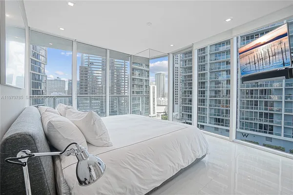 a bed sitting in a room next to a large window