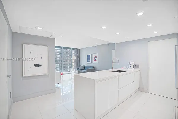 a kitchen with sink and white cabinets