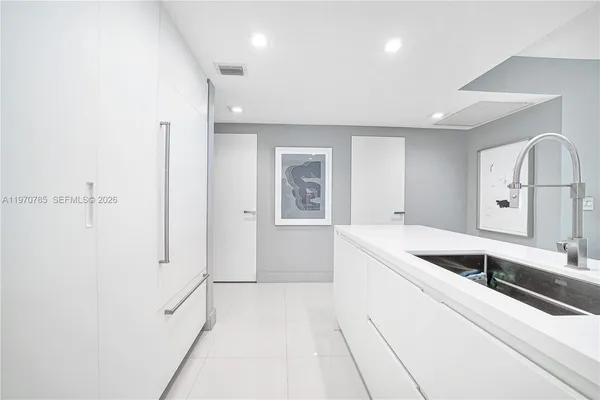 a large white kitchen with a sink