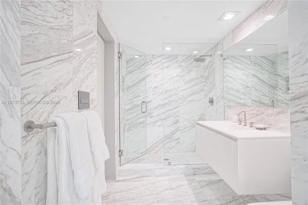 a bathroom with a sink a mirror and shower