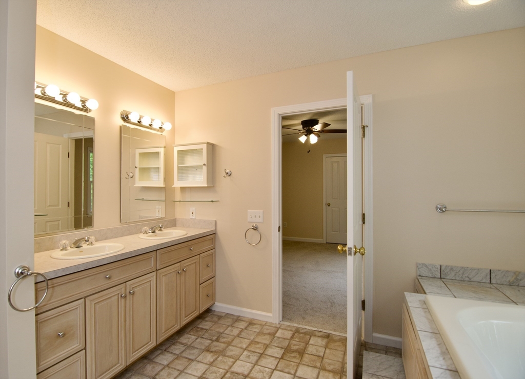 97 Monson Road Brimfield, MA 01010 - Photo 34 of 42 a spacious bathroom with a double vanity sink a mirror and a bathtub