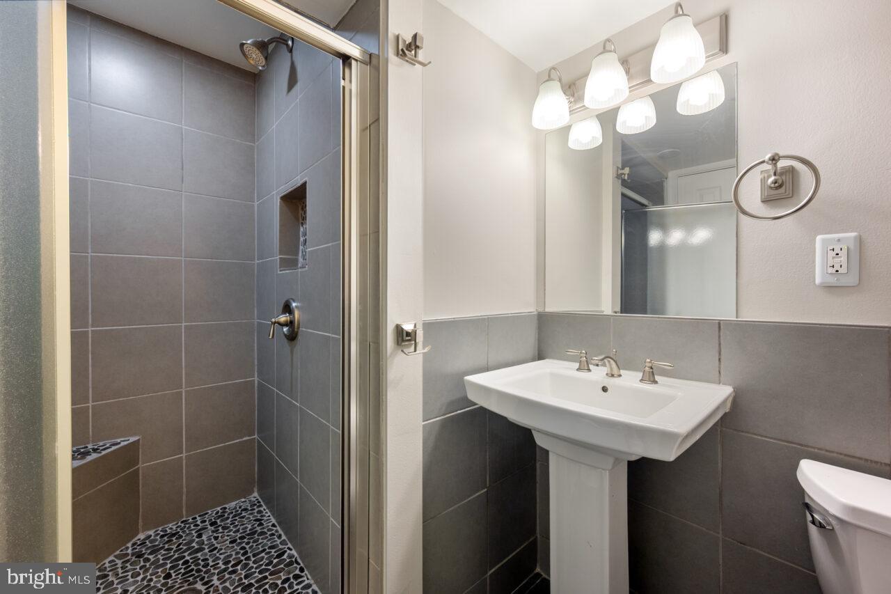 2405 Cedar Lane Vienna, VA 22180 - Photo 17 of 56 a bathroom with a sink a light fixture and a toilet
