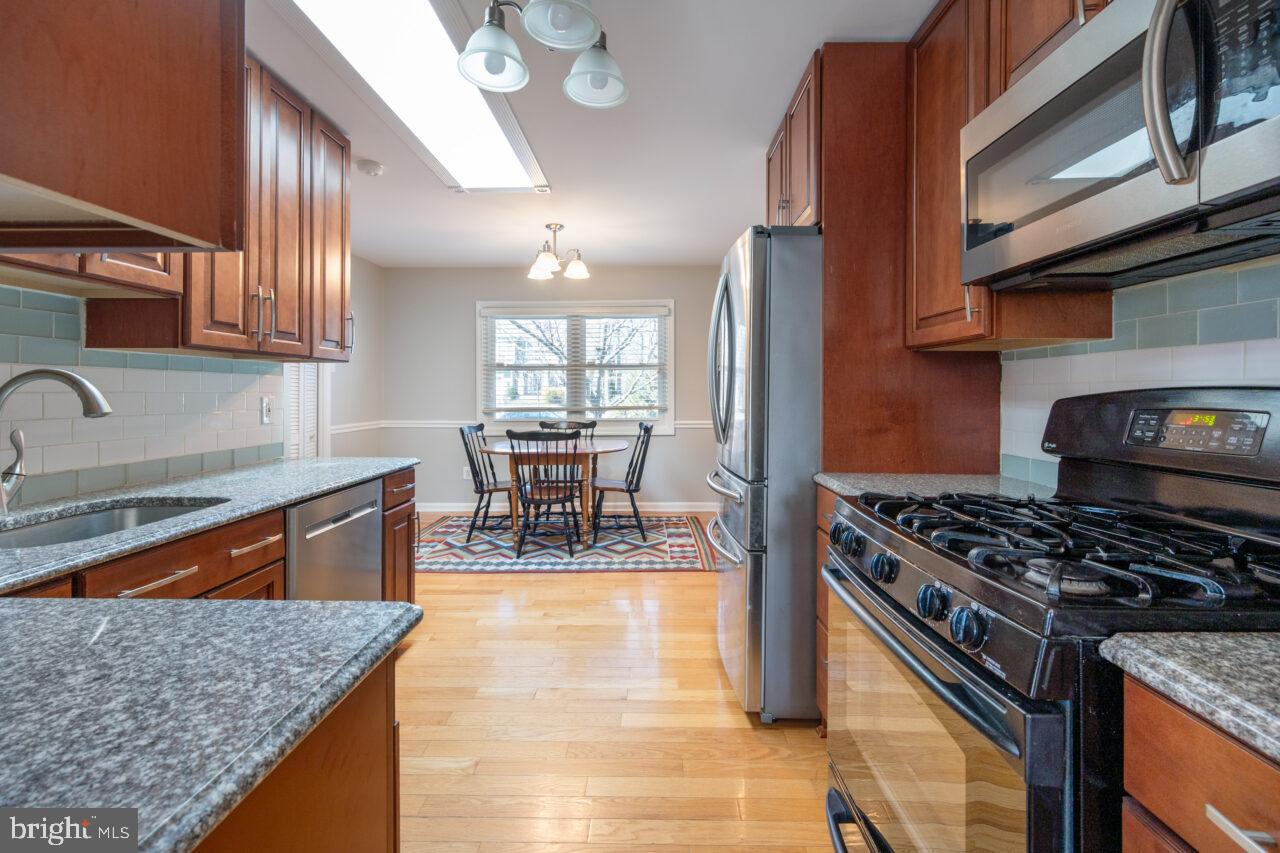 2405 Cedar Lane Vienna, VA 22180 - Photo 35 of 56 a kitchen with stainless steel appliances granite countertop a stove a sink and a microwave