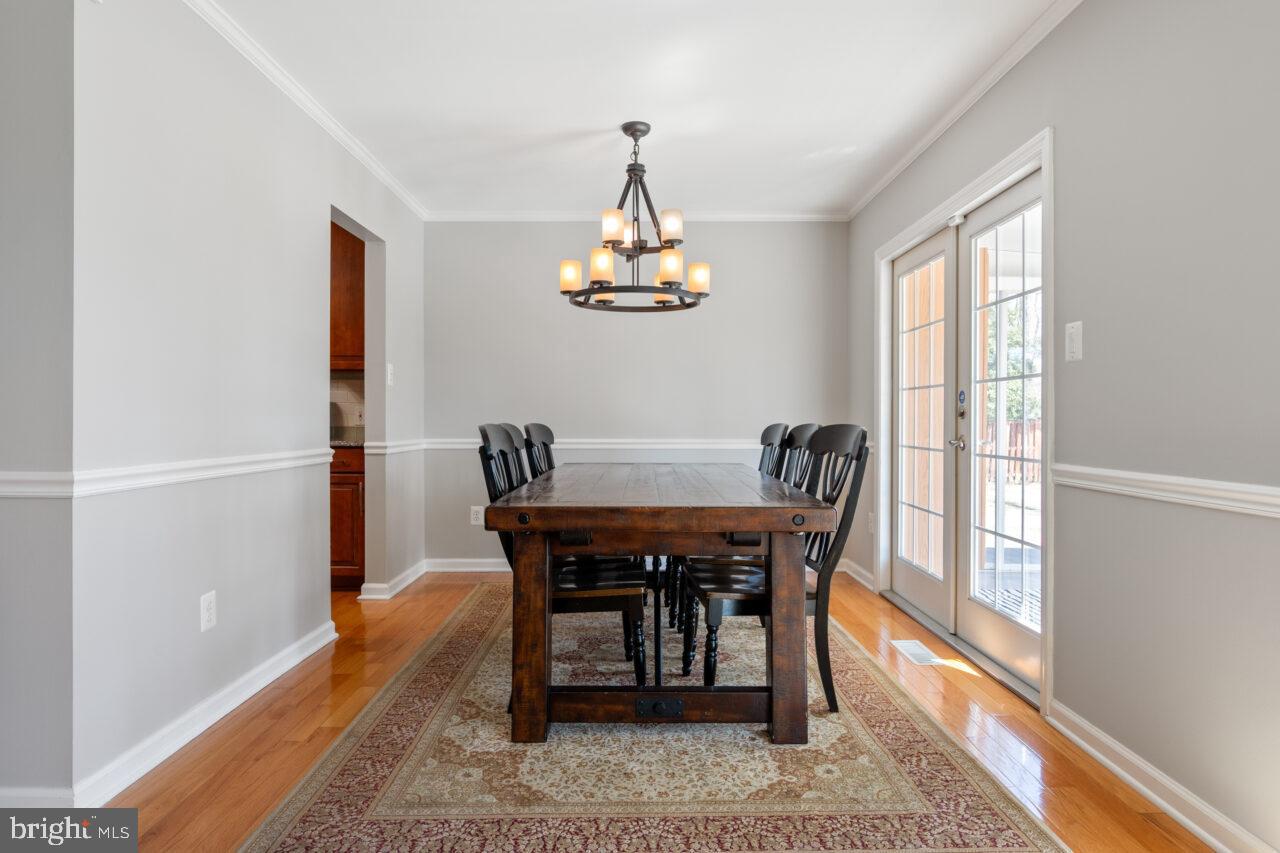 2405 Cedar Lane Vienna, VA 22180 - Photo 43 of 56 a dining room with furniture a chandelier and wooden floor