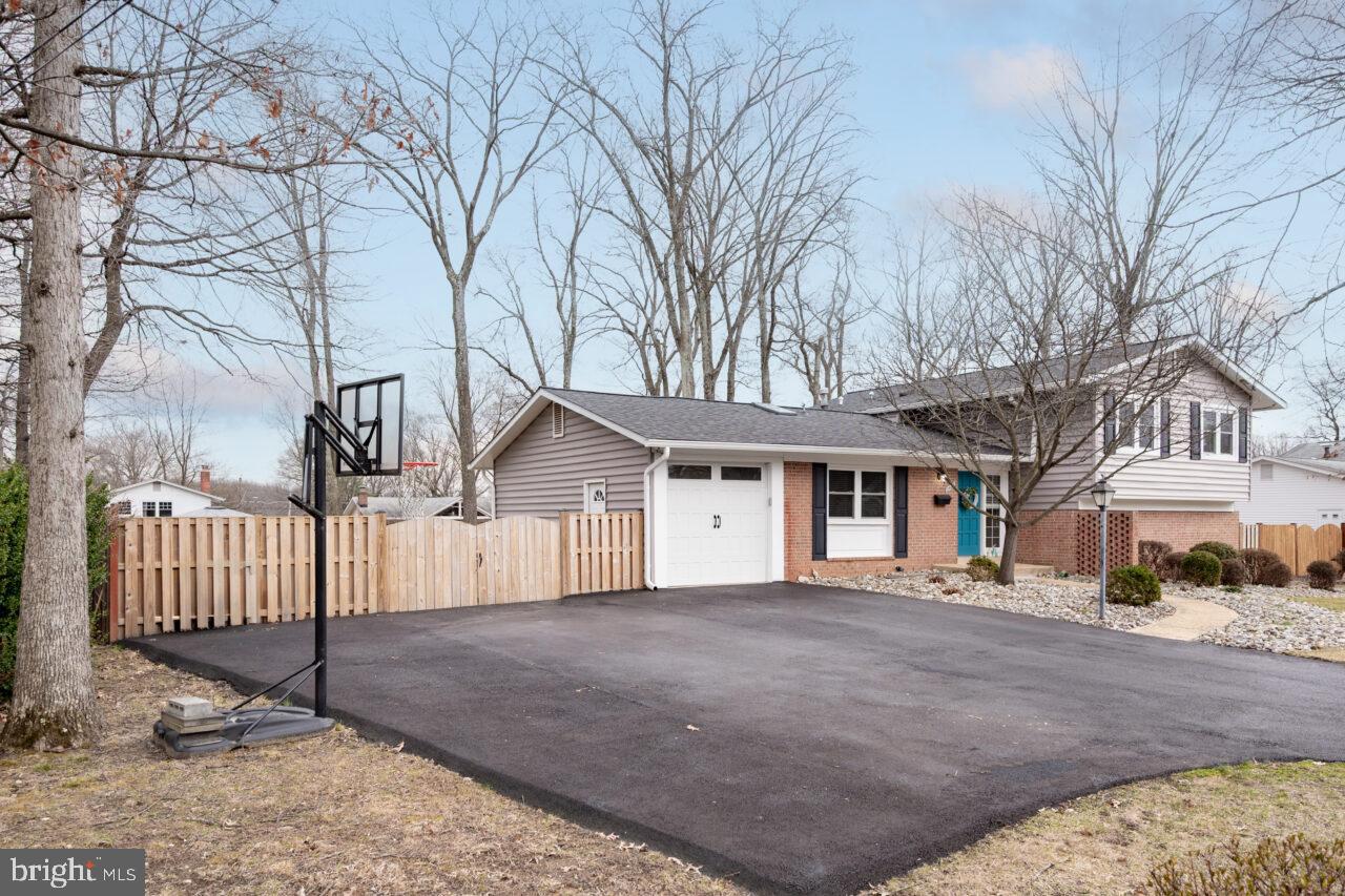 2405 Cedar Lane Vienna, VA 22180 - Photo 55 of 56 a view of a white house with a large tree and wooden fence