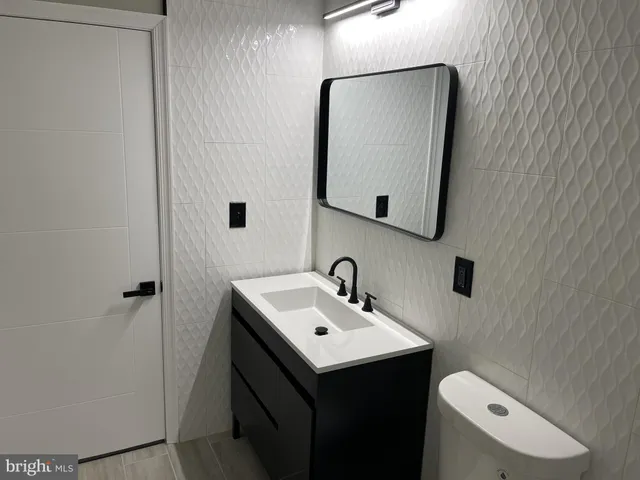 a bathroom with a toilet sink and mirror