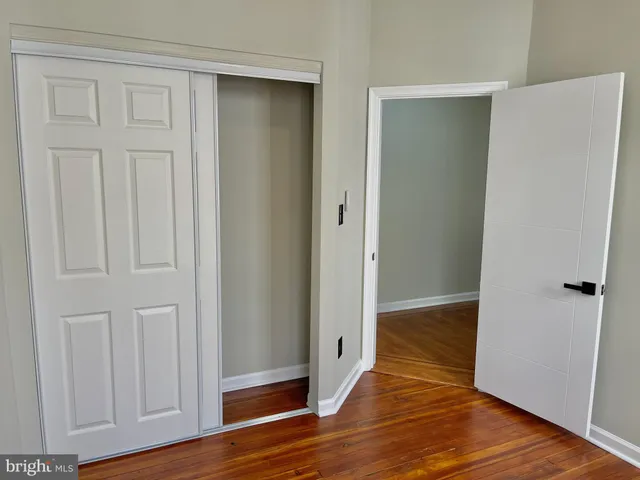 an empty room with wooden floor and closet