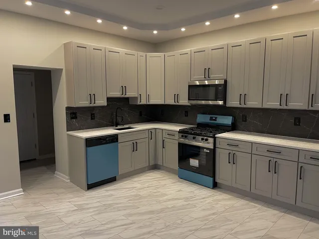 a kitchen with stainless steel appliances granite countertop a stove a sink and a refrigerator
