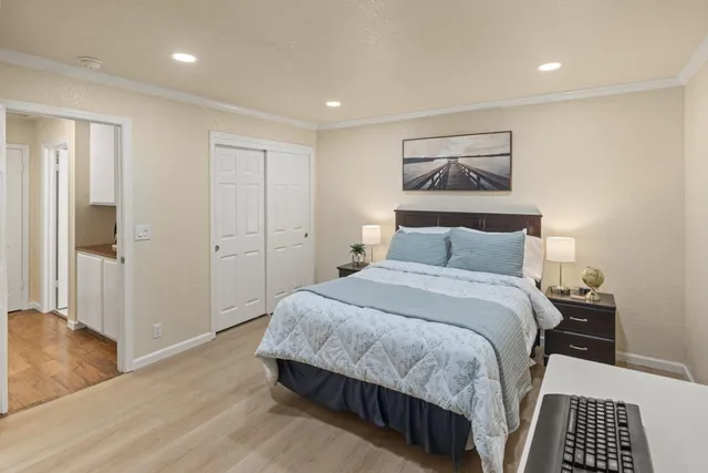 a bedroom with a bed and wooden floor