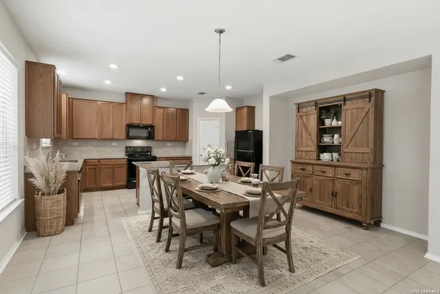 a kitchen with stainless steel appliances granite countertop a refrigerator and a stove top oven