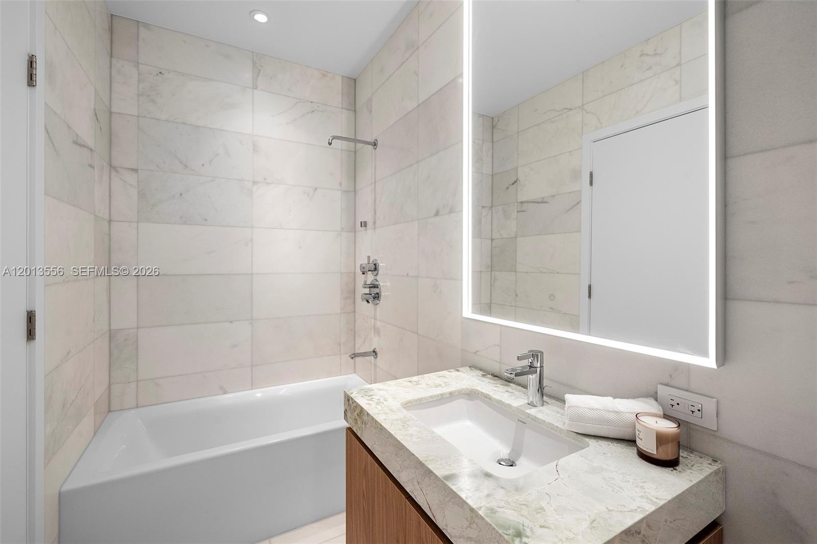 500 Alton Road, Unit 502 Miami Beach, FL 33139 - Photo 11 of 11 a bathroom with a granite countertop tub sink and mirror