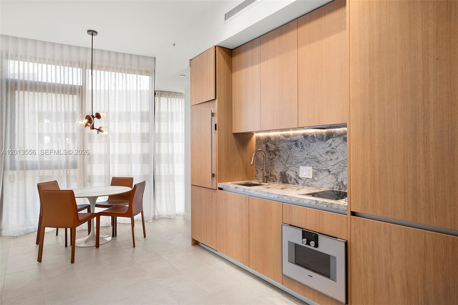 500 Alton Road, Unit 502 Miami Beach, FL 33139 - Photo 7 of 11 a kitchen with stainless steel appliances granite countertop a stove a sink and a refrigerator with wooden floors
