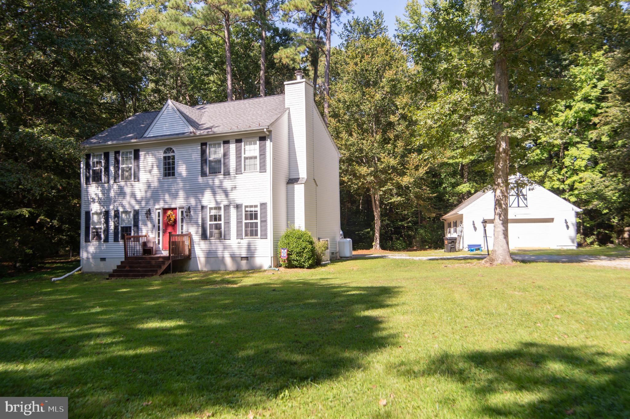 a view of a house with a big yard and large trees