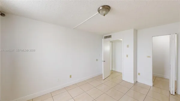 a walk in closet with wooden floor