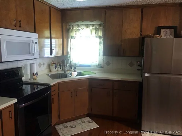 a kitchen with a sink a refrigerator and cabinets
