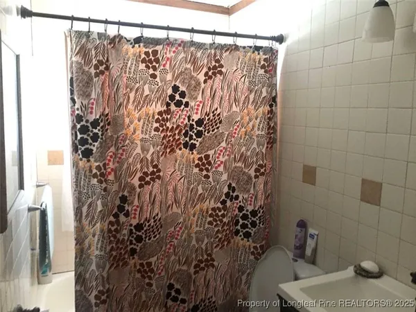 a bathroom with a shower curtain and a toilet
