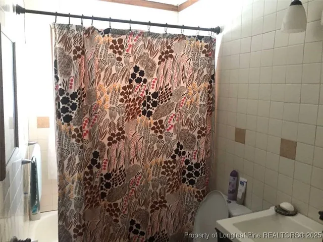 a bathroom with a shower curtain and a toilet
