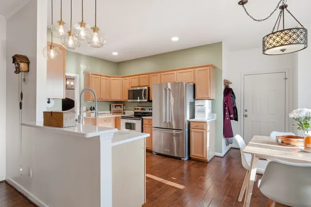 a kitchen with stainless steel appliances granite countertop a refrigerator and a stove top oven