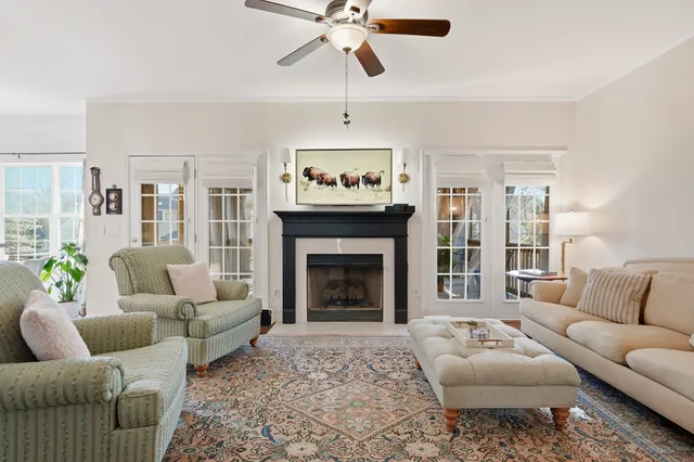 a living room with furniture a fireplace and a chandelier