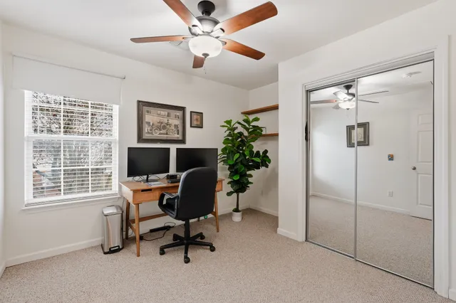 a view of a workspace with furniture and a window