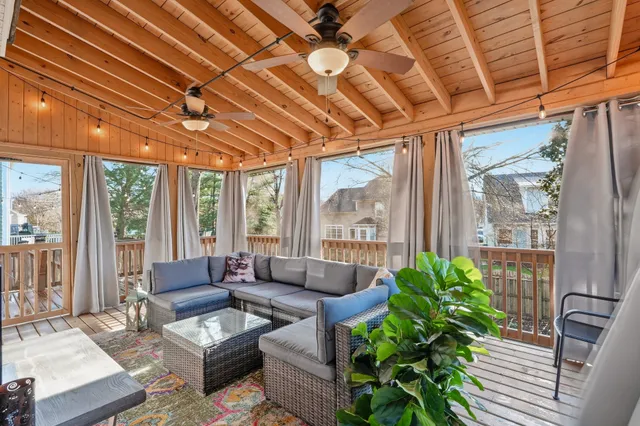a living room with patio furniture and a potted plant