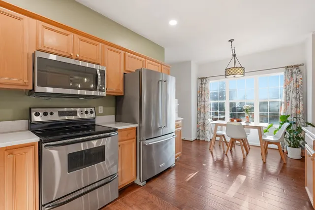 a kitchen with stainless steel appliances a stove a refrigerator and a microwave
