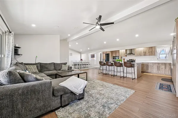 a view of a kitchen with granite countertop stainless steel appliances refrigerator dining table and chairs