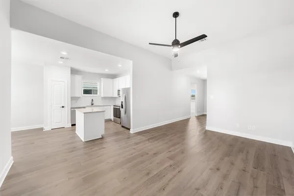 a view of empty room with wooden floor