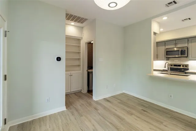a view of kitchen with wooden floor and electronic appliances