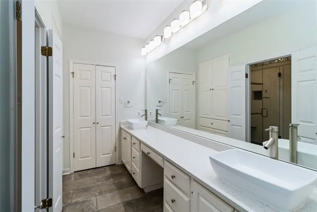 a spacious bathroom with a double vanity sink a mirror and a bathtub