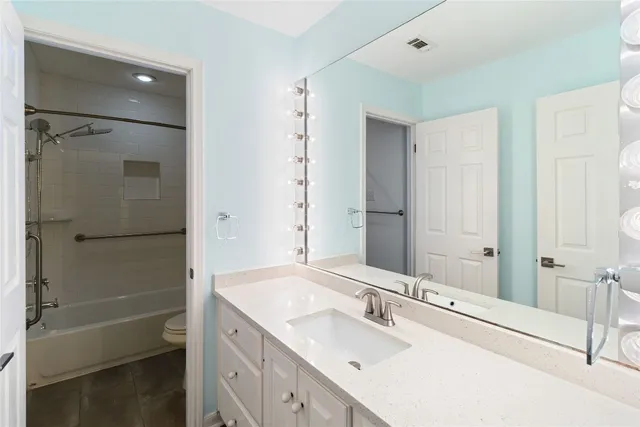 a bathroom with a granite countertop sink shower and a mirror
