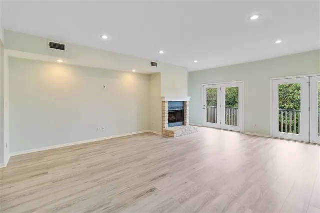 an empty room with wooden floor and fireplace